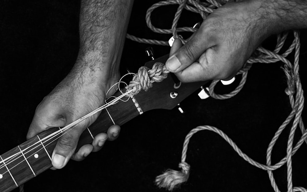 grayscale photo of person holding rope