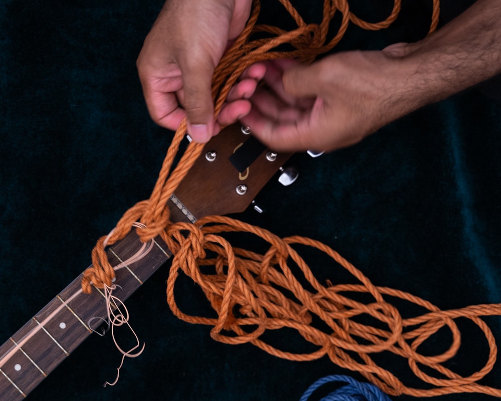 person holding brown leather belt