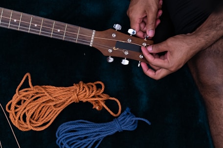 Musician happily tuning a guitar after a quick maintenance session.