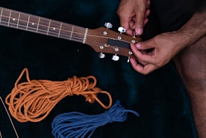 Technician adjusting guitar bridge for perfect intonation