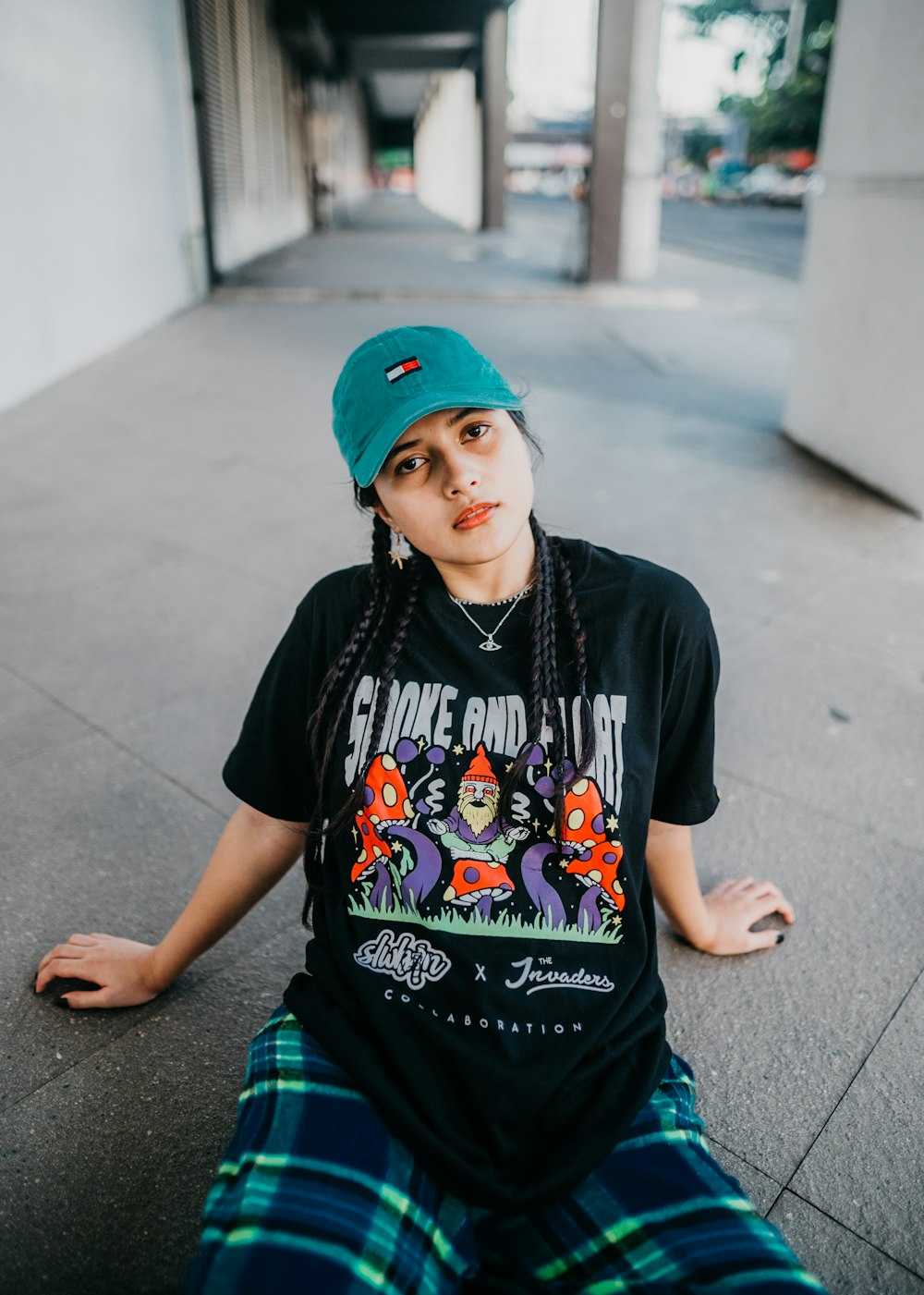 boy in black crew neck t-shirt and blue and white plaid shorts standing on gray