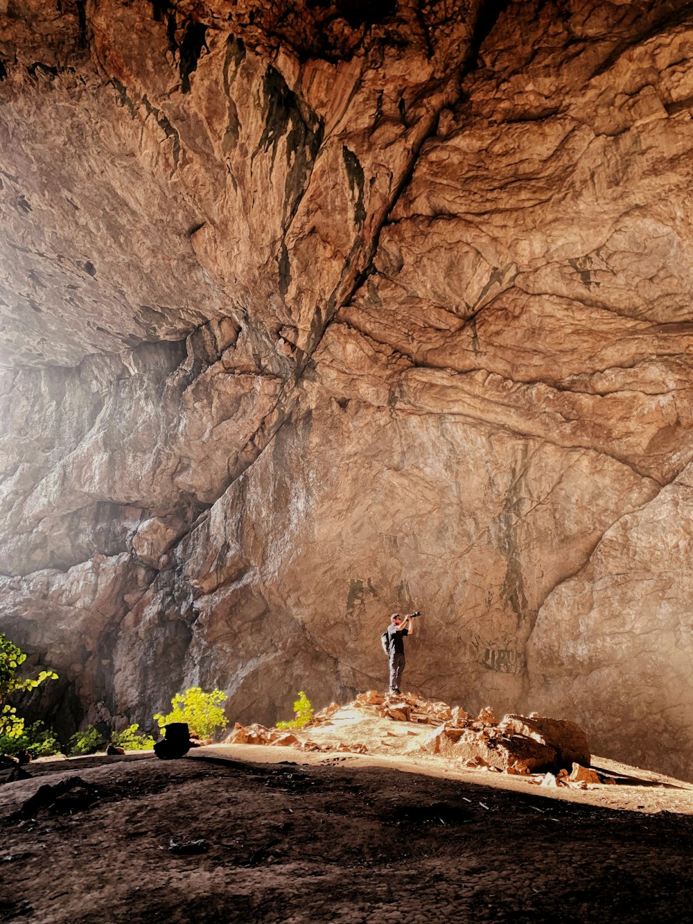 person in black jacket standing on brown rock formation during daytime