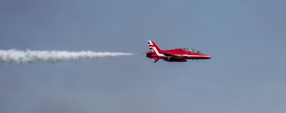 avião a jato vermelho no ar