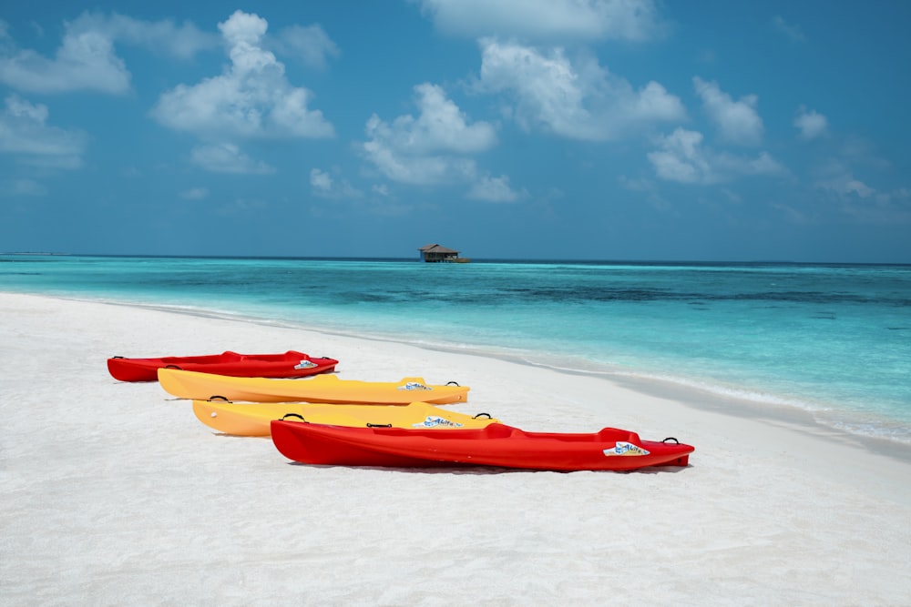 red kayak on sea shore during daytime