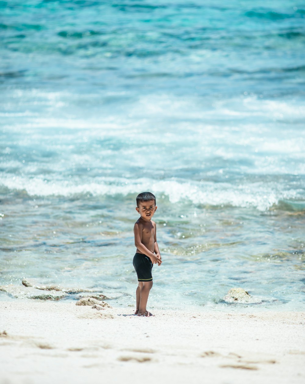 woman in black bikini standing on beach during daytime