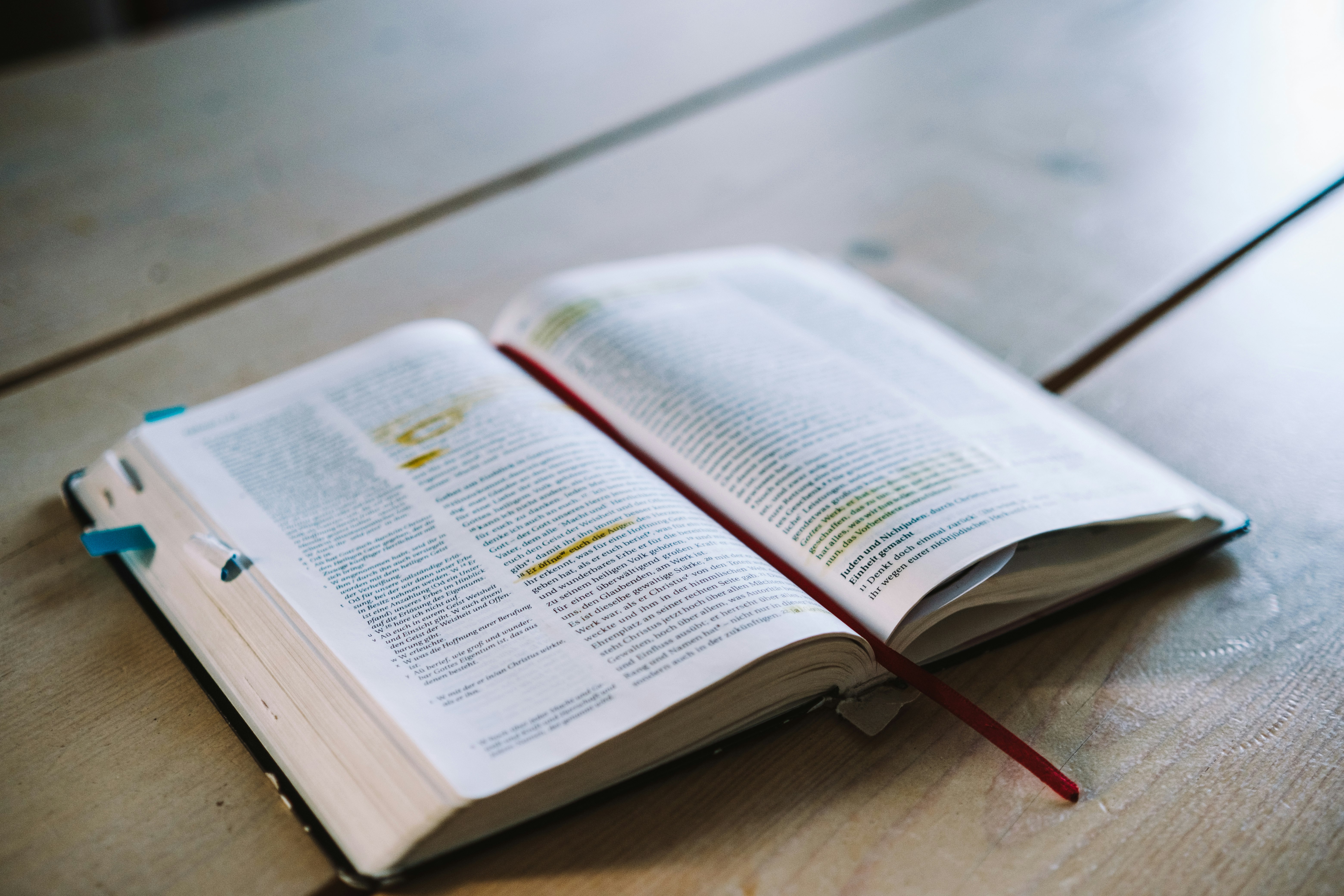 opened book on brown wooden table