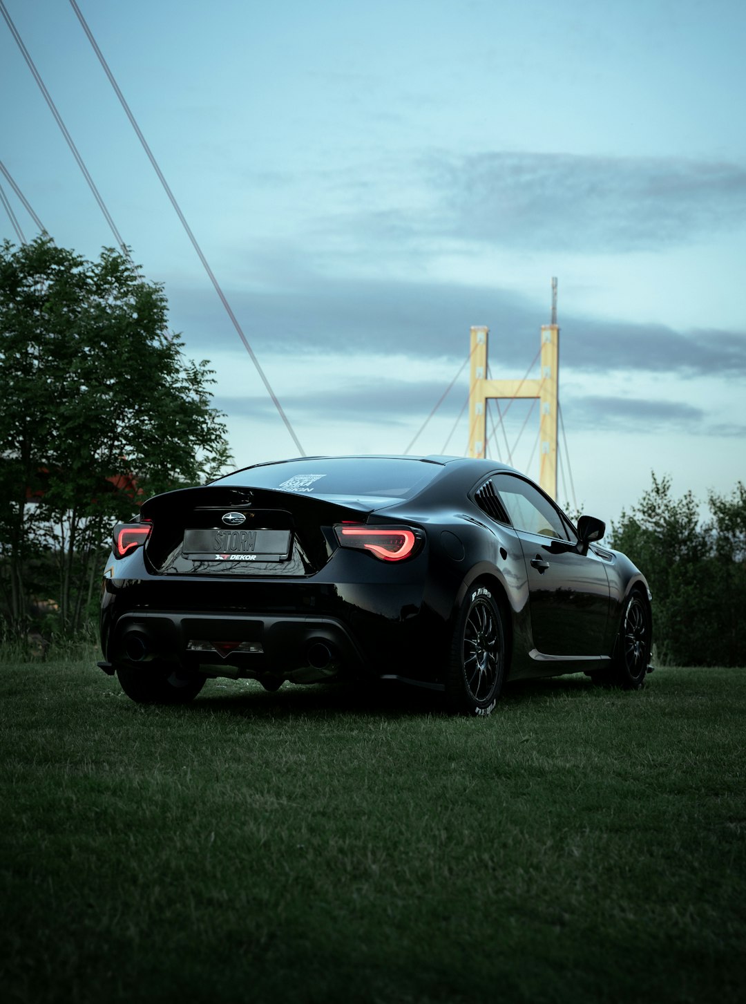 black porsche 911 parked on green grass field during daytime