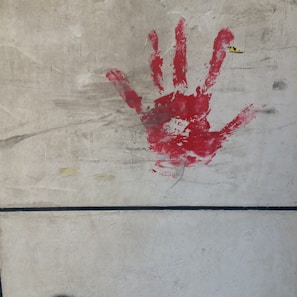 Blood-red claw marks smeared across a faded gold wall with peeling paint.