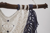 Un collar de macramé terminado en tonos tierra, exhibido sobre un fondo de tela rústica.