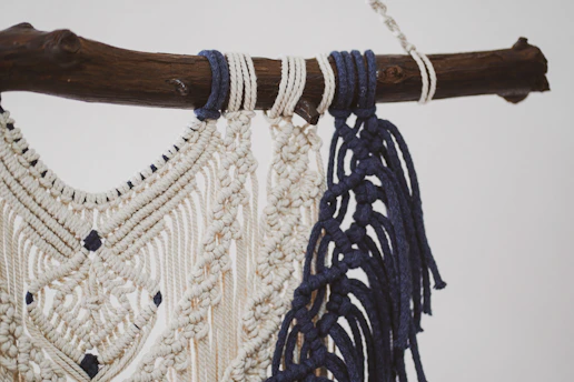 Close-up of delicate macrame knots forming a minimalist wall hanging in natural cotton thread.