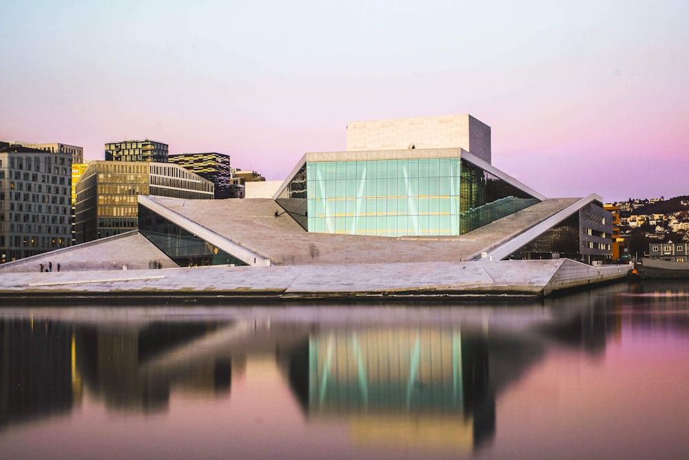 Bâtiment en béton brun et blanc près d’un plan d’eau pendant la journée