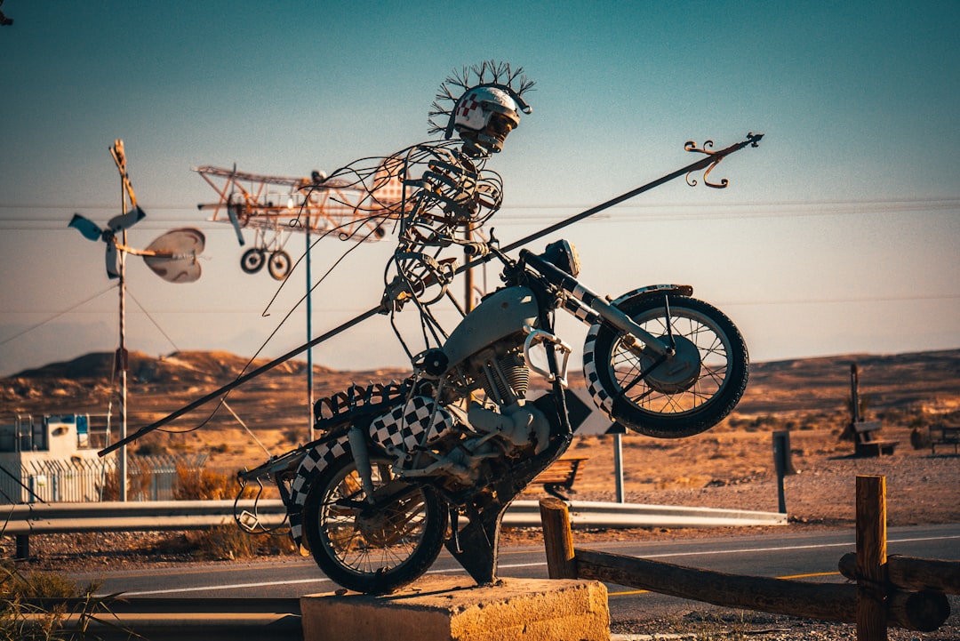 black and gray motorcycle parked on brown wooden post during daytime