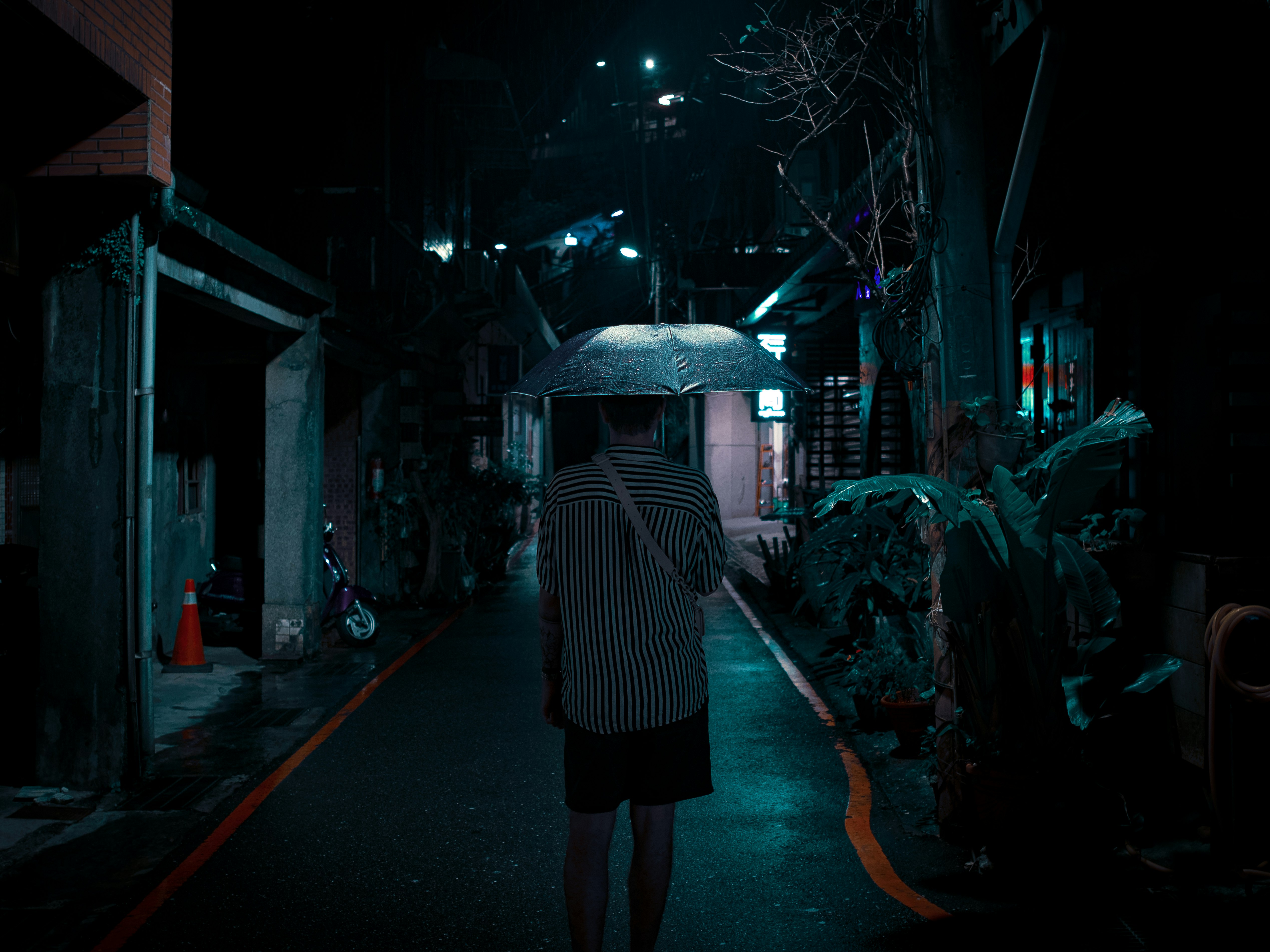 woman in white and black stripe long sleeve shirt and black skirt holding umbrella walking on with with with on