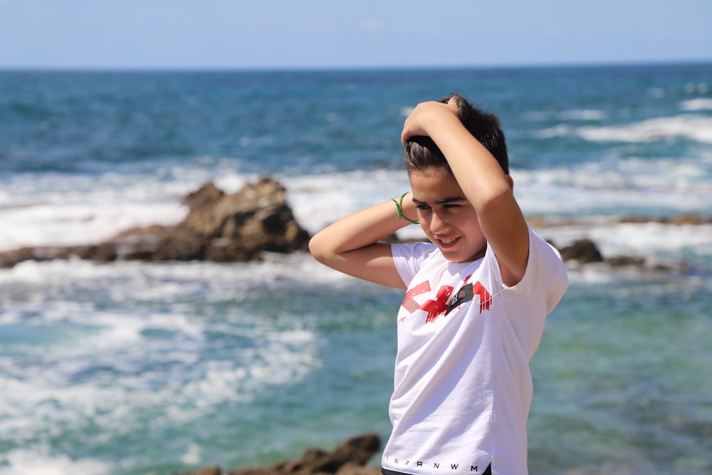 woman in white shirt standing near body of water during daytime