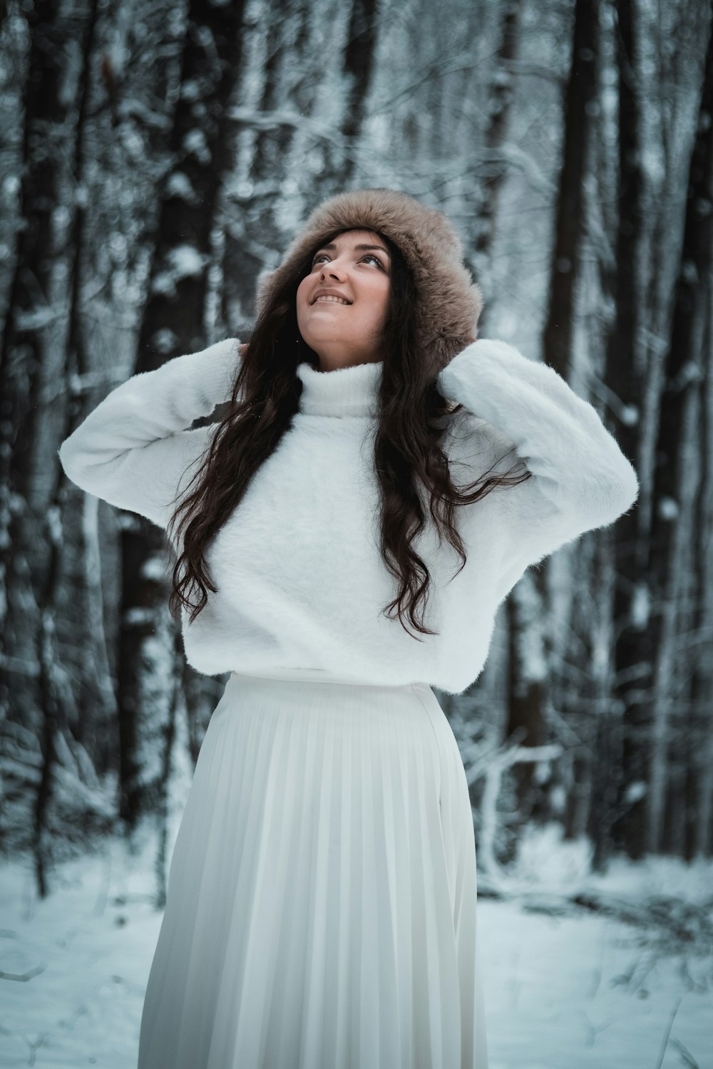 woman in white long sleeve dress standing near trees during daytime