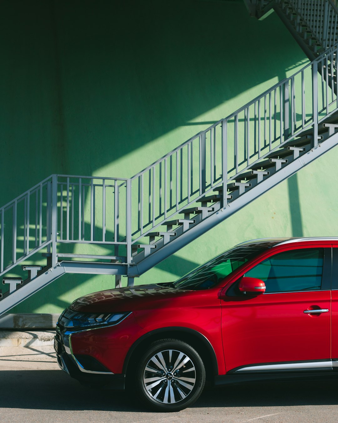 red car parked on the side of the stairs