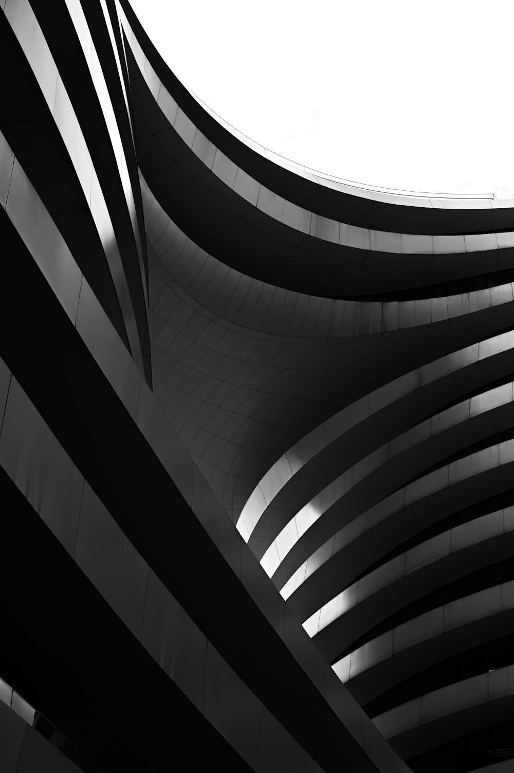 a black and white photo of a curved building