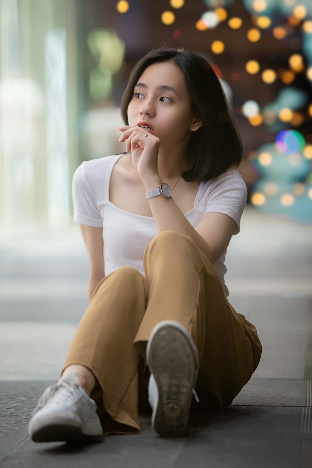 woman in white shirt and brown skirt sitting on floor