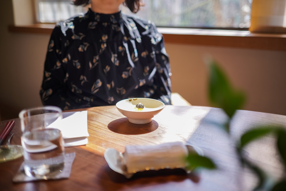 woman in black and white floral long sleeve shirt sitting at the table