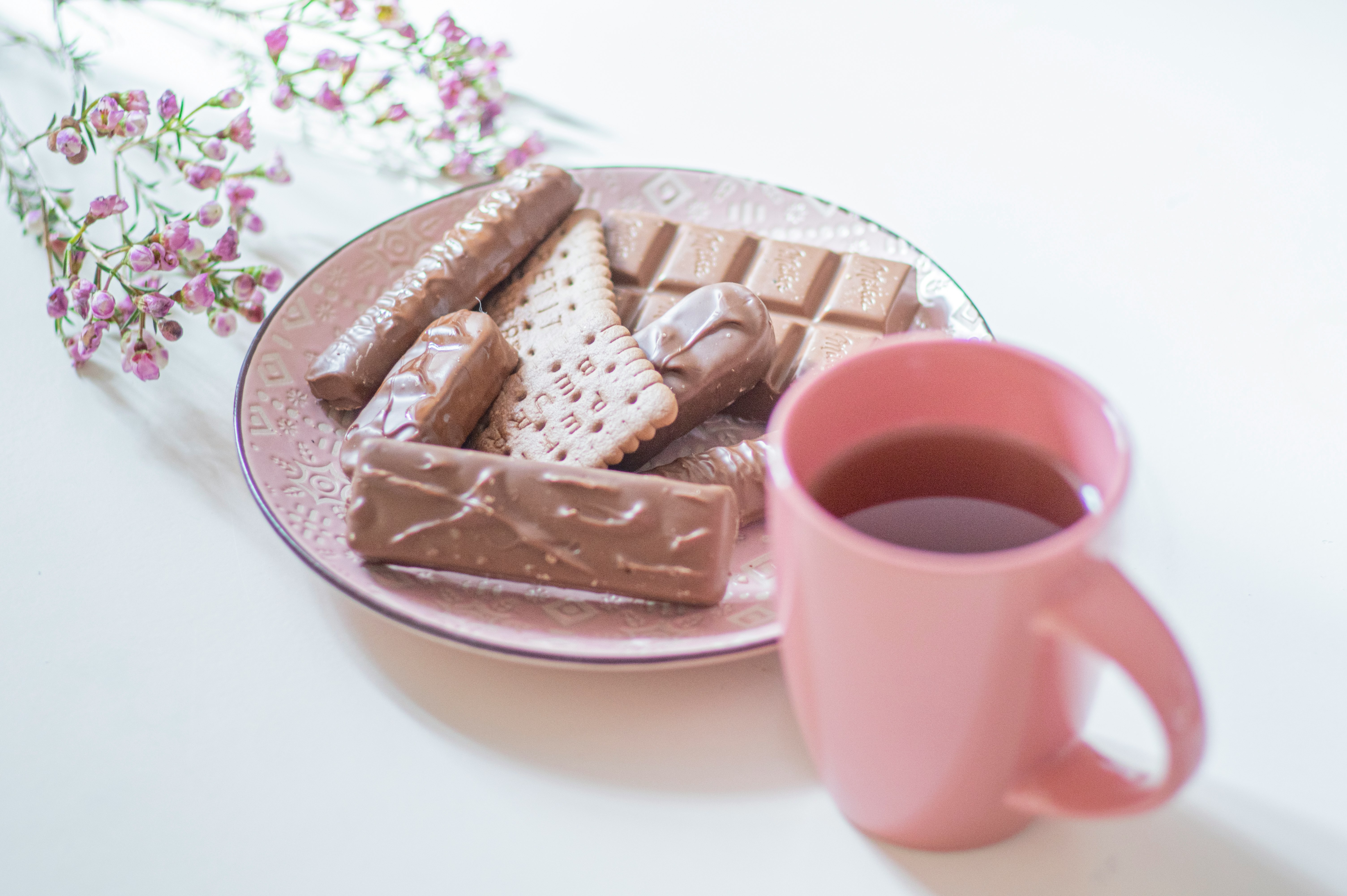 white ceramic mug on pink ceramic saucer