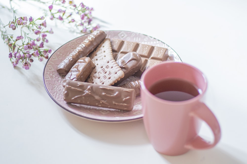 white ceramic mug on pink ceramic saucer