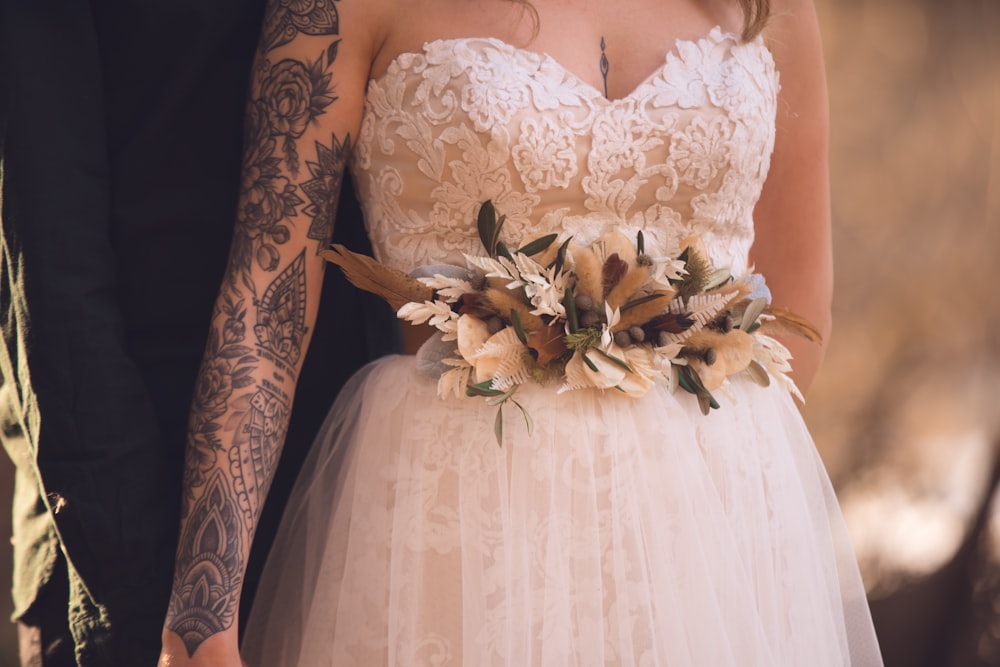 woman in white floral dress holding white flower