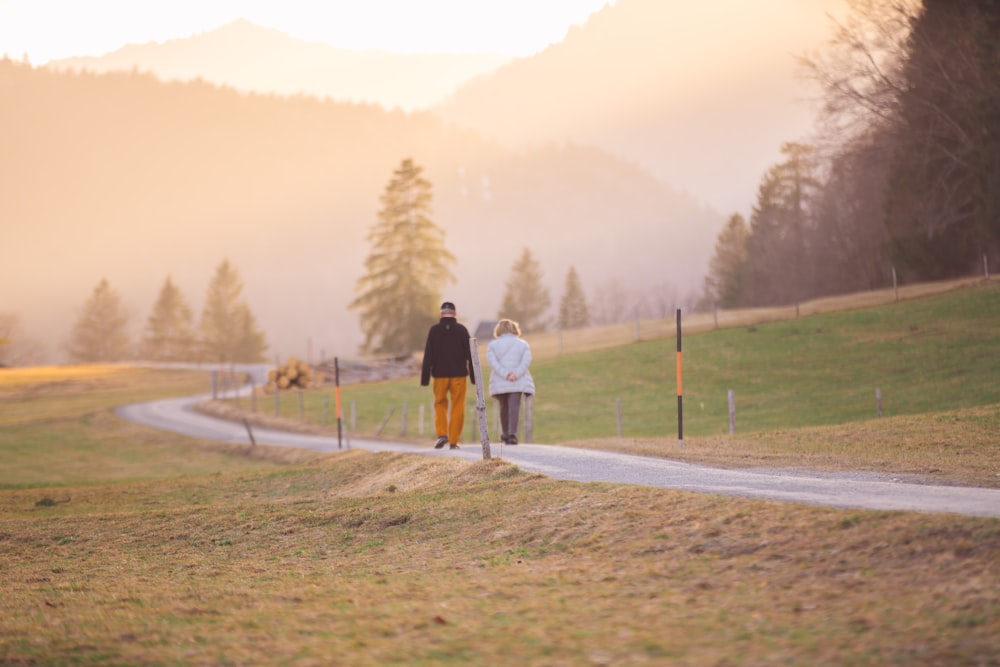 woman in black jacket and white pants walking on road during daytime