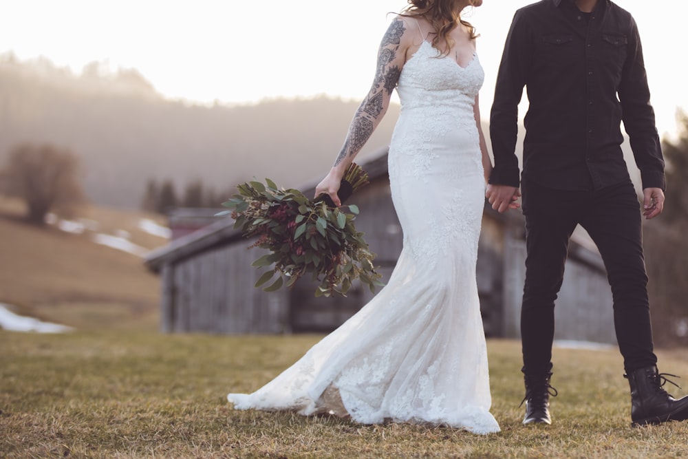 mujer en vestido de novia blanco de pie junto al hombre en traje negro