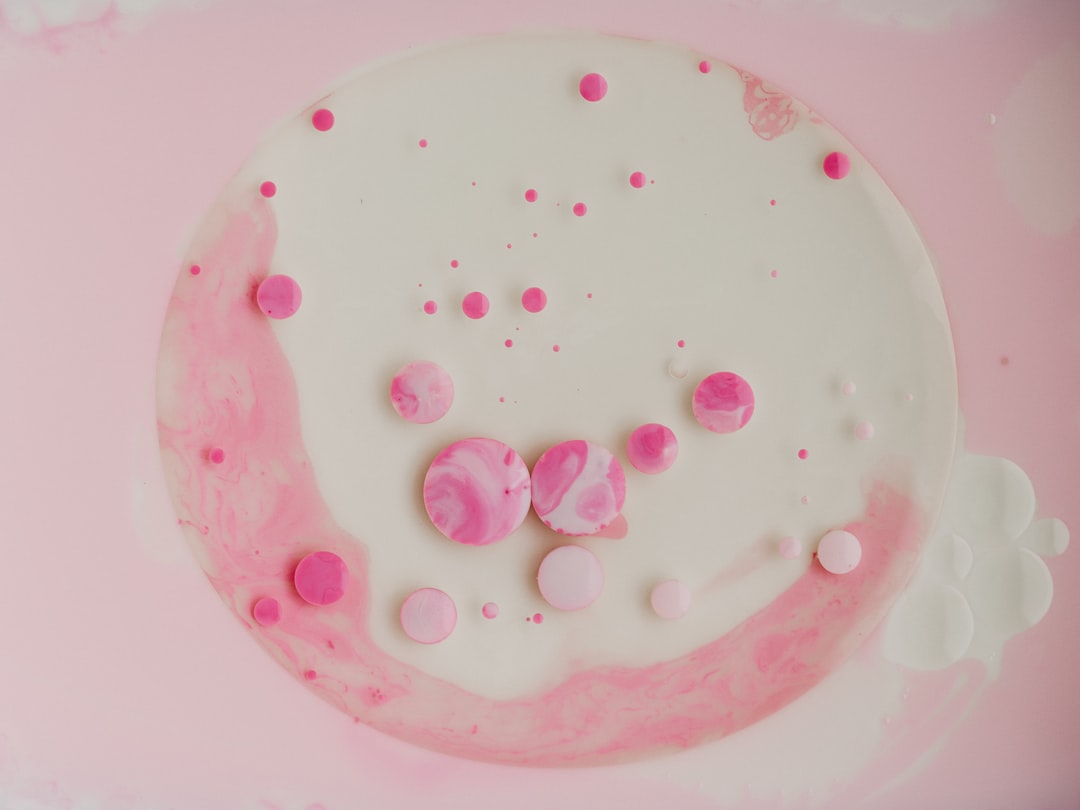 pink round candy on white ceramic plate