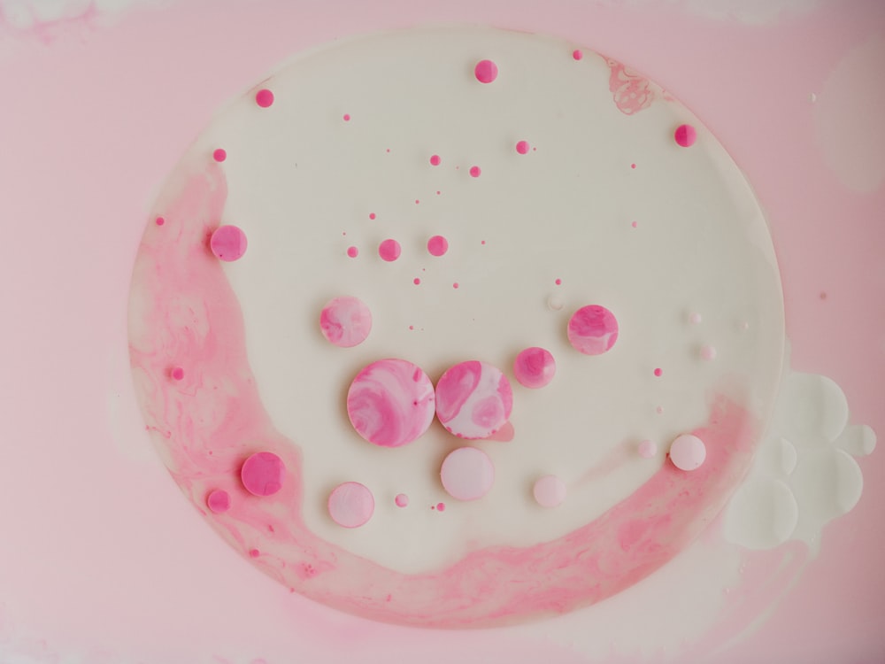 pink round candy on white ceramic plate