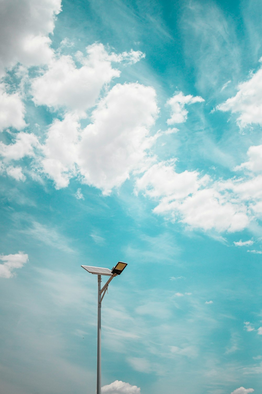 white and brown basketball hoop under blue sky and white clouds during daytime
