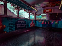 The interior of a bus or vehicle is decorated with vibrant holiday themes, featuring a 'Genting Winter Wonderland' banner. The walls display illustrations of teddy bears, colorful Christmas stockings, and gifts. The windows are adorned with festive garlands, creating a cheerful holiday atmosphere.