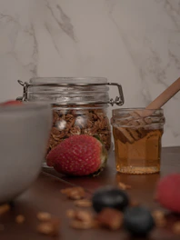 A rustic wooden table displaying gluten-free granola with seeds and dried fruits.