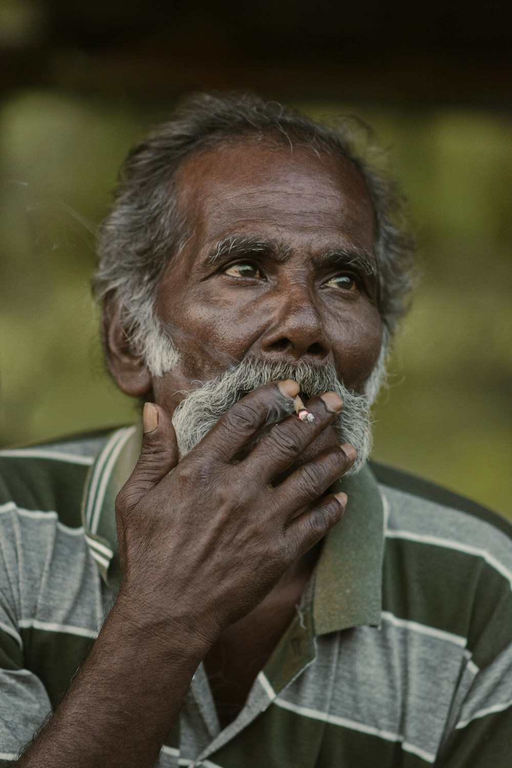 an old man with a moustache smoking a cigarette