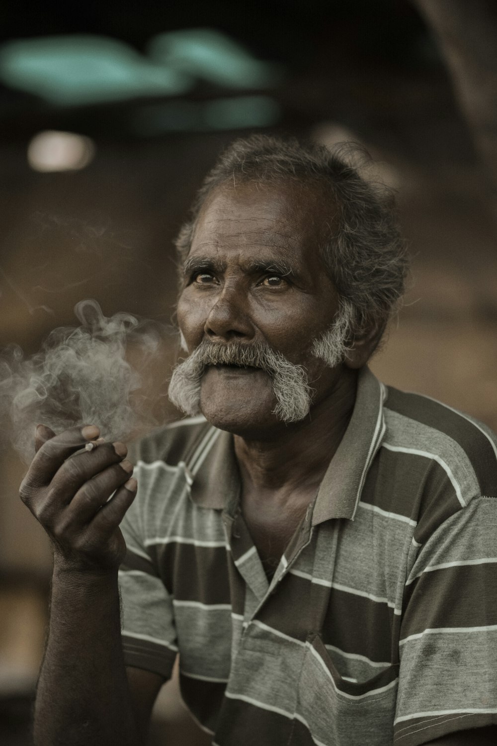 a man with a mustache smoking a cigarette