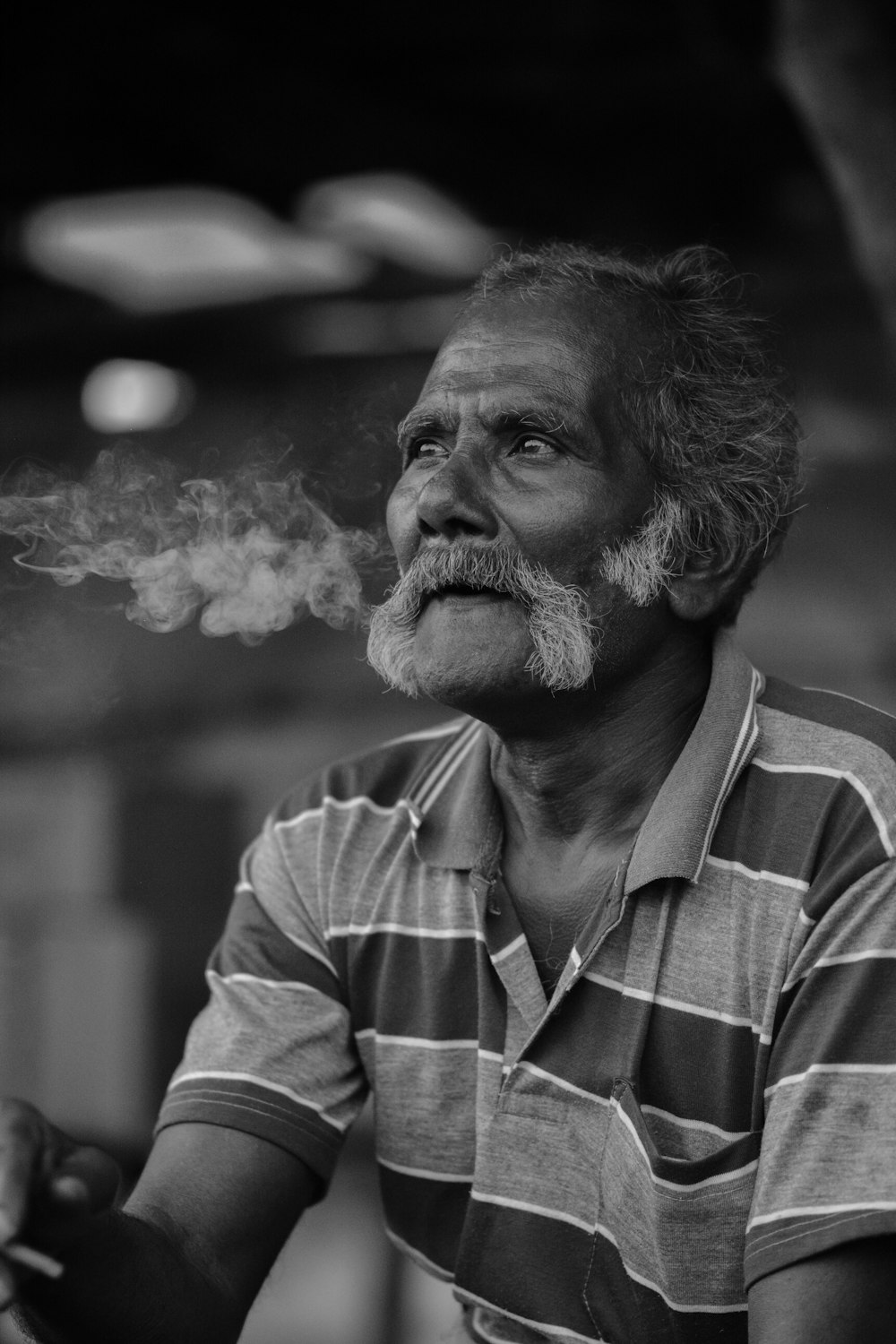 a man smoking a cigarette in a black and white photo