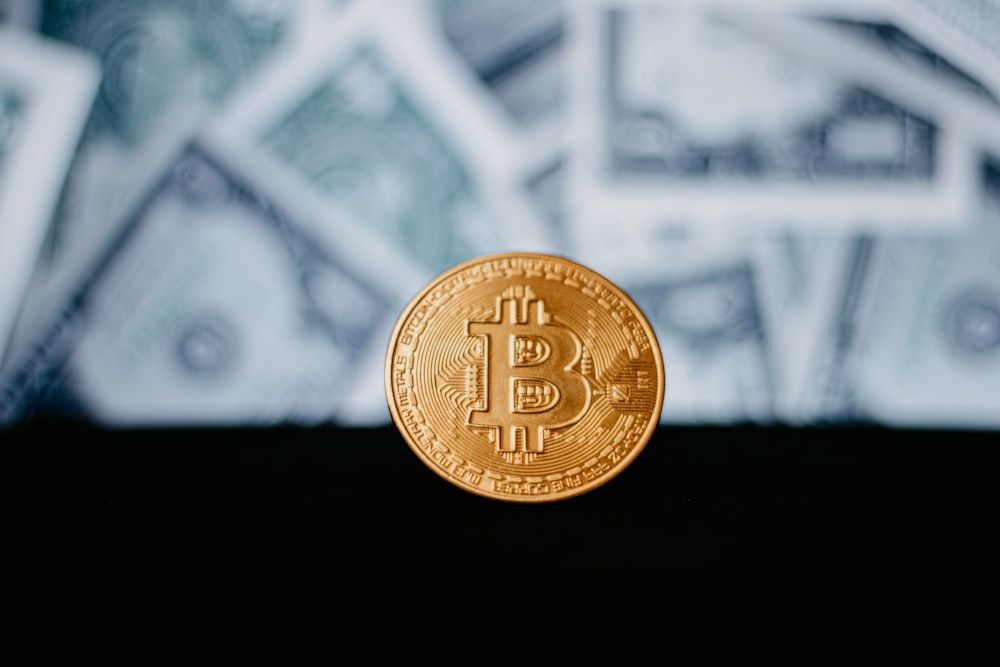 gold round coin on black surface