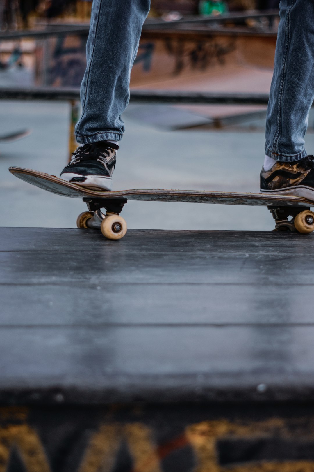 person in blue denim jeans riding black skateboard