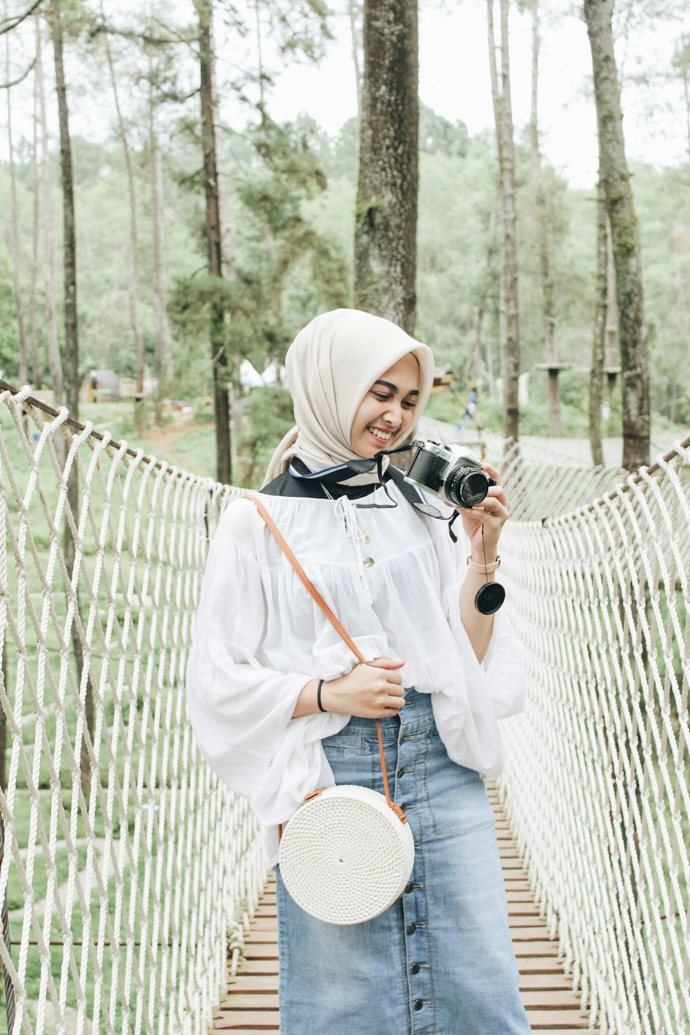 Frau im weißen Hijab mit schwarzer DSLR-Kamera