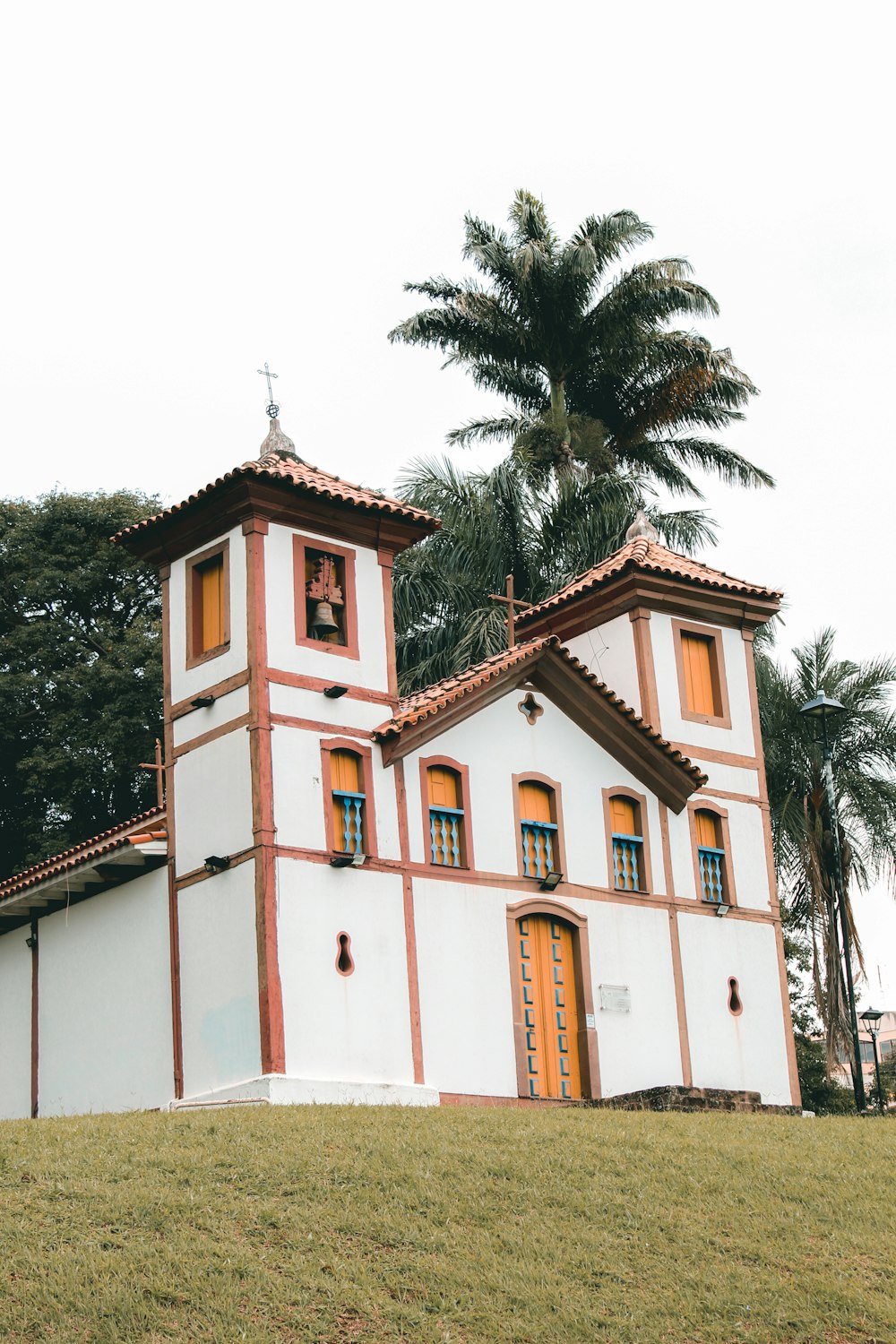 white and red concrete building near green trees during daytime