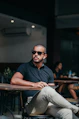 man in black polo shirt wearing black sunglasses sitting on chair