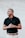 man in black polo shirt standing near white wall