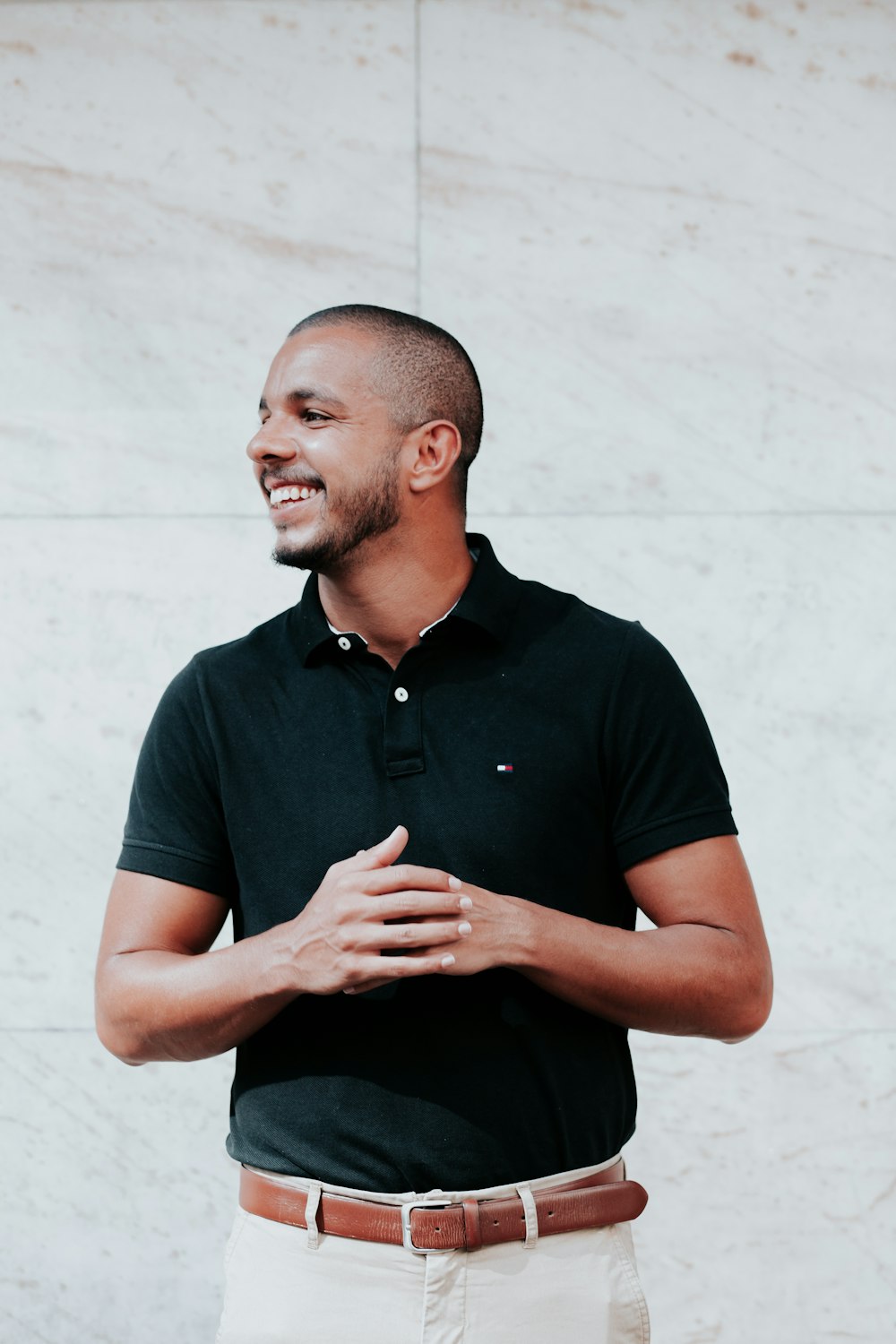 man in black polo shirt standing near white wall photo – Free Happy Image  on Unsplash