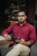 man in red dress shirt holding black tablet computer