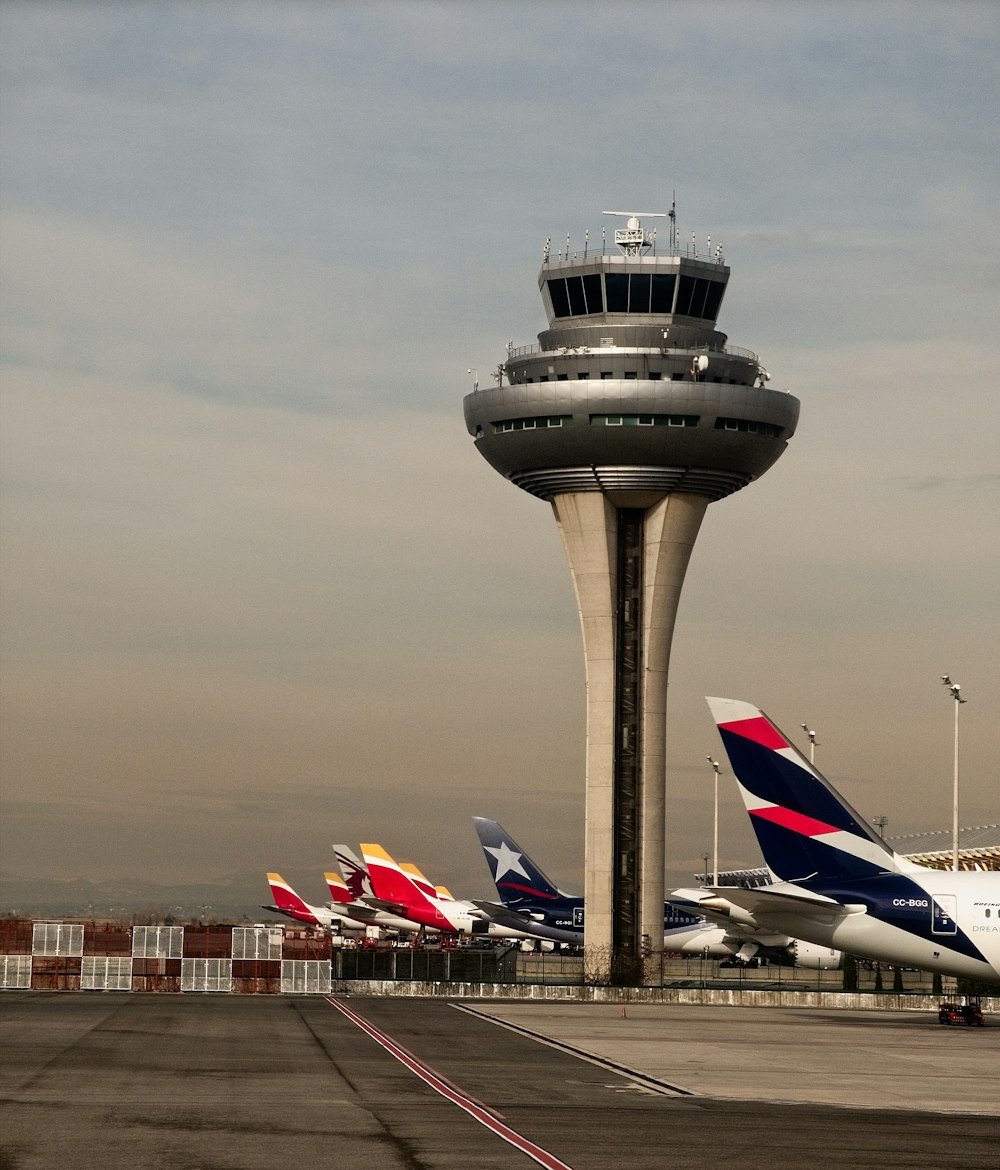 weißes und rotes Flugzeug tagsüber am Flughafen