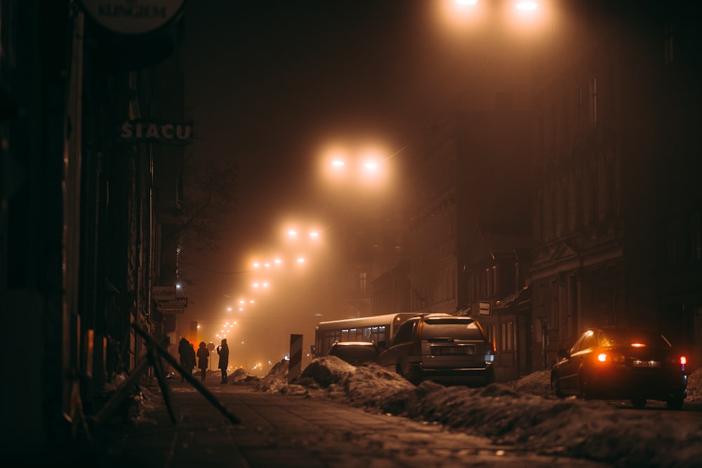 Voiture blanche garée à côté d’un bâtiment brun pendant la nuit