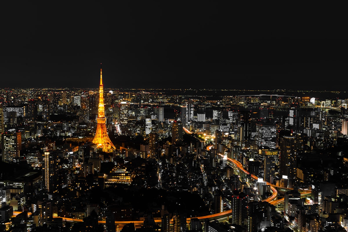 Tokyo city skyline at night with illuminated high-rise buildings reflecting Japan's financial district and monetary policy influence