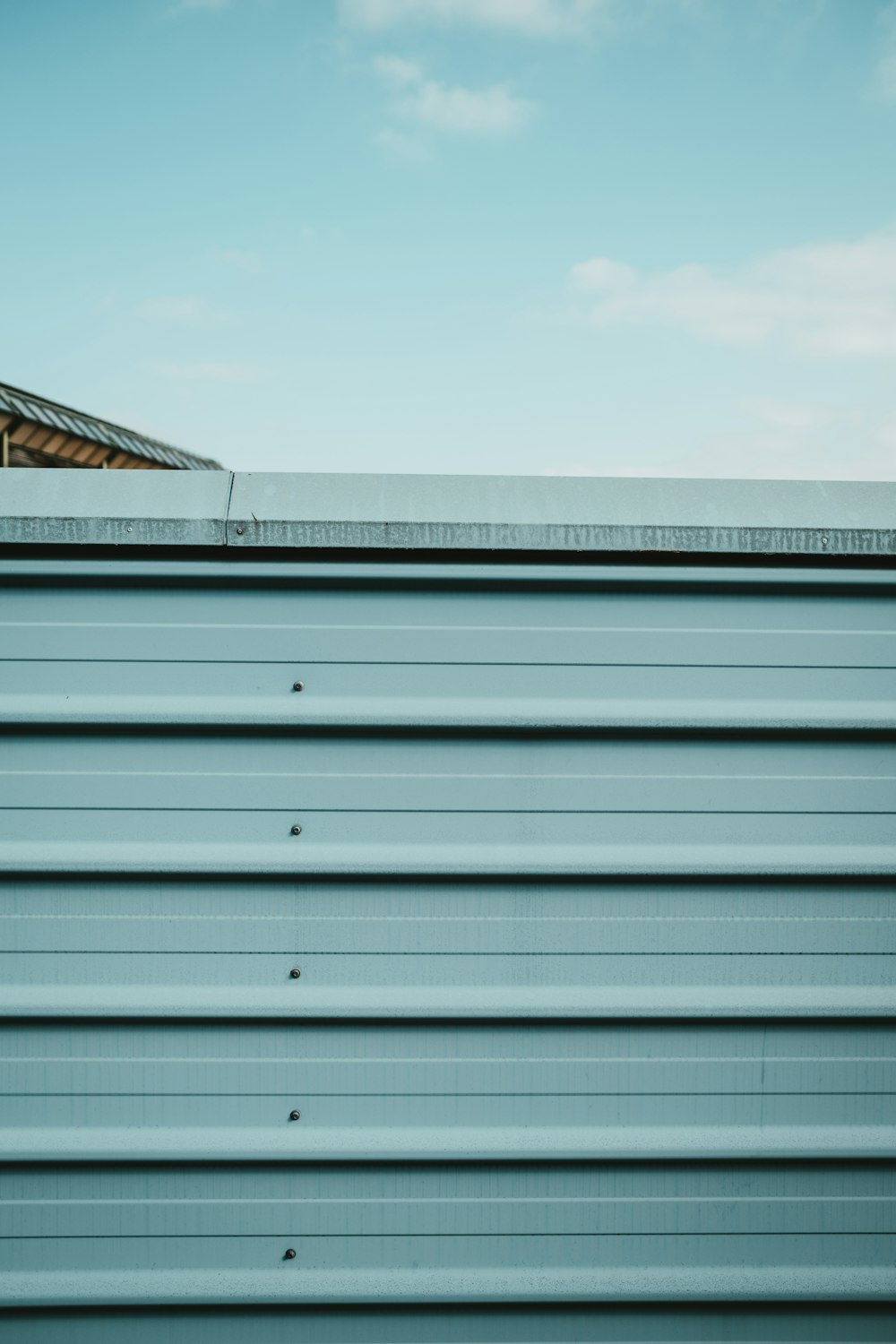 white and gray steel garage door under white cloudy sky during daytime