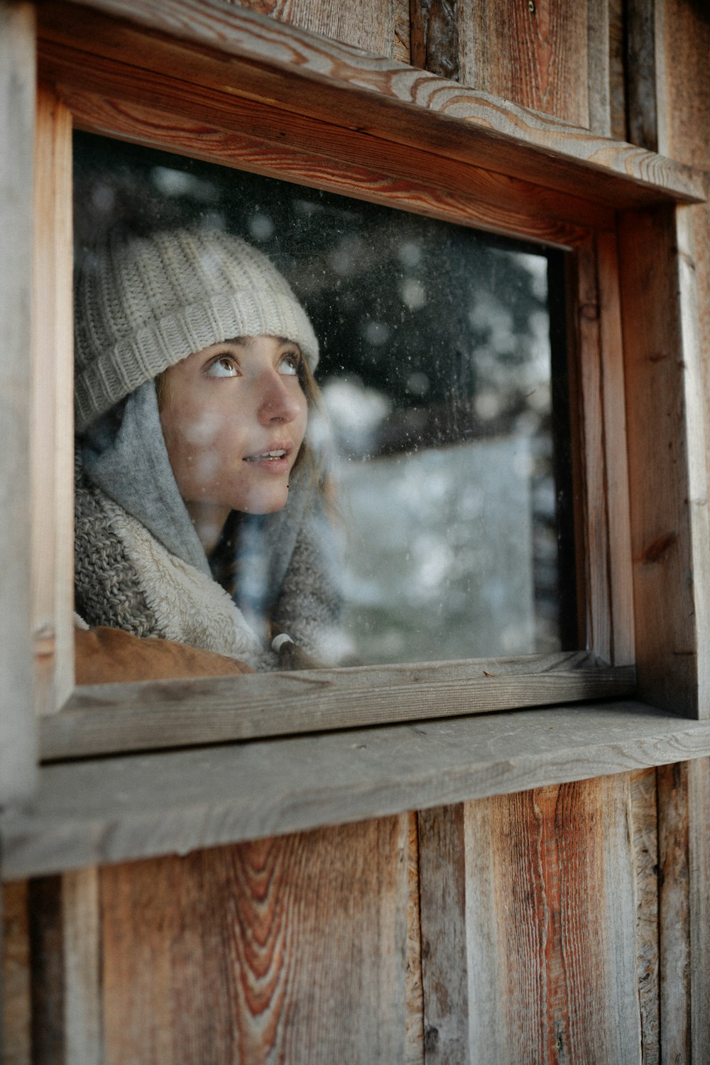 woman in gray knit cap in brown wooden frame