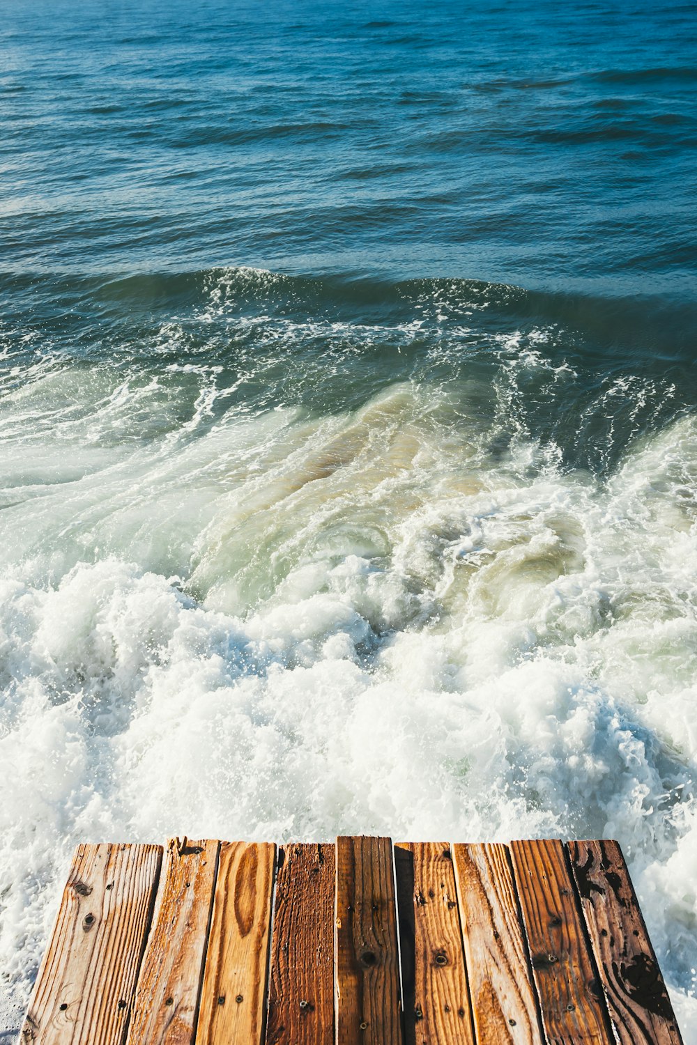 doca de madeira marrom no mar durante o dia